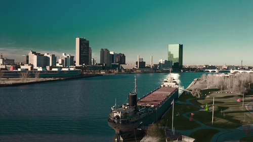 Aerial view of Toledo Ohio downtown skyline along the Maumee River featuring waterfront, historic ship, and city buildings for Ohio visitors seeking closest recreational cannabis dispensary in Michigan