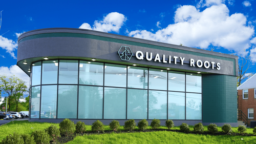 Exterior view of Quality Roots Marlton recreational cannabis dispensary in New Jersey featuring modern glass facade, branded signage, and parking lot in Burlington County